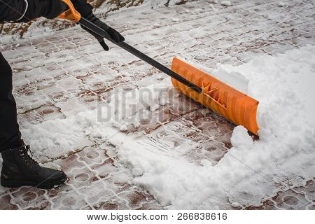 After A Snowfall, A Man Clears Snow From The Road In Winter, Work In The Winter Season