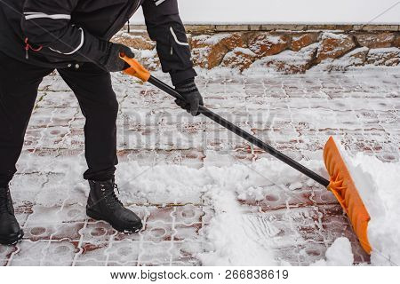 After A Snowfall, A Man Clears Snow From The Road In Winter, Work In The Winter Season