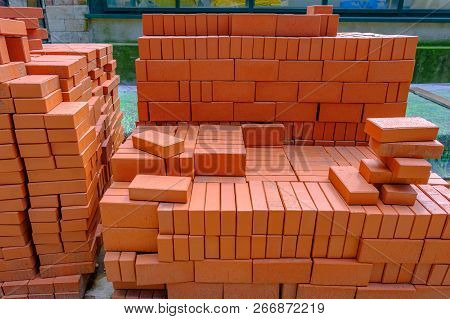 Stack Of Red Bricks For Build Construction.