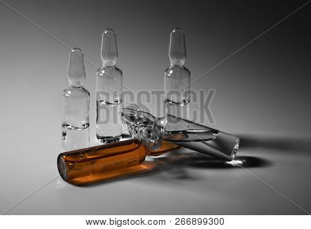 Row Of Ampulas With Medicine On Gray Background