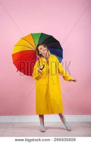 Woman With Rainbow Umbrella Near Color Wall
