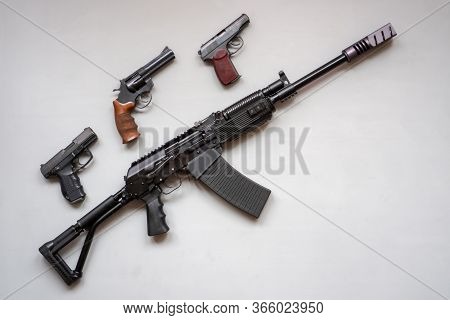 Close-up Of A Boar Machine Gun And Pistol On A Gray Background. Isolated. Flat Lay