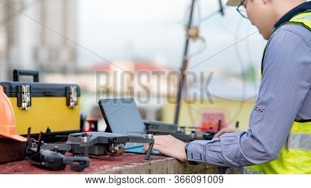 Asian Engineer Man Working With Drone, Laptop And Working Tools At Construction Site. Male Worker Us