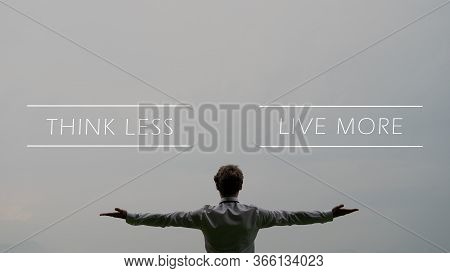 Think Less Live More Sign Over A Businessman Standing Under Grey Sky With His Arms Spread Widely.