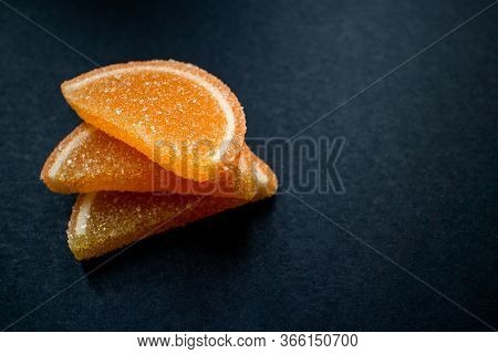 Orange Slices Of Marmalade On A Black Background.