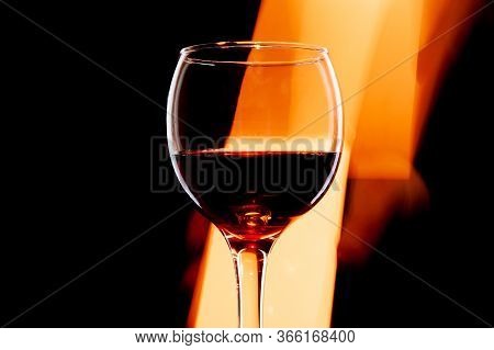 Moving Light Behind Wine Glass Over A Dark Background