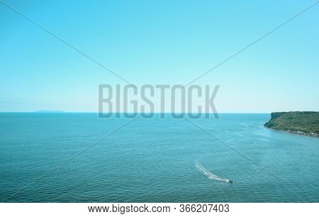 Blue Clear Sky And Turquoise Sea Landscape. A Boat Floats In The Distance. Summer Sea Bay. Vladivost
