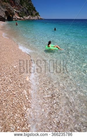 Konavle, Croatia - June 28, 2019: People Spend Vacation At Pasjaca Beach Below Cliffs In Konavle Reg