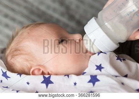 Feeding A Small Newborn Girl With Formula From A Bottle. Artificial Feeding