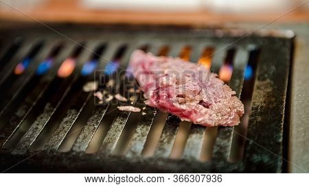 Thinly Sliced Japanese Wagyu Beef On Grille For Barbecue. Yakiniku Style