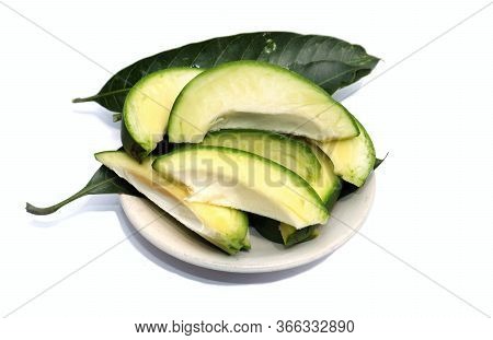 Raw Mango Cuts With Mango Leaves In A Plate In Horizontal Orientation