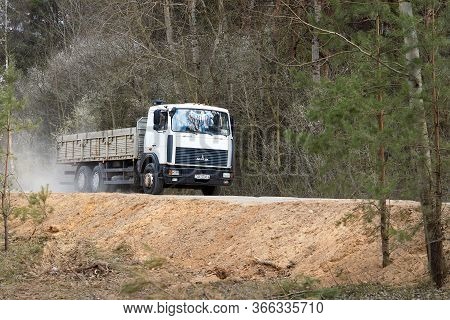Grodno, Belarus - April 2020: Heavy Laden Multi-ton Truck Maz With White Cab And Gray Body Rides Alo