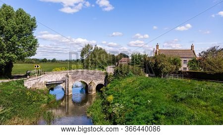 A Pretty Village Cottage Next To A Countryside River In Somerset.