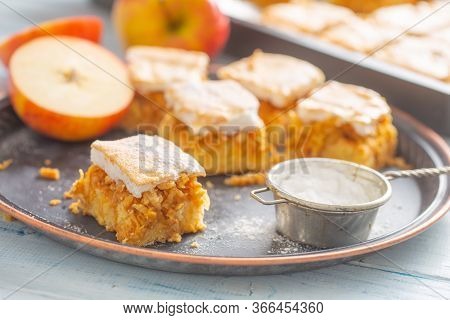 Five Cubes Of Apple Plie With A Cream Topping, Sugar Sieve And Half-cut Apple Next To It.