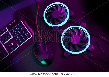 Modern Computer Fan With Blue Light Lying Next To Computer Gaming Mouse And Enlightened Gaming Keybo