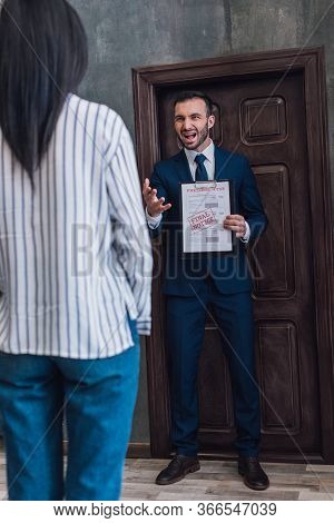 Angry Collector With Documents With Foreclosure And Final Notice Lettering Shouting In Front Of Woma