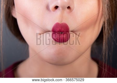 Beautiful girl plays with her lips, macro detail. Young woman makes funny faces