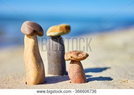 Three Stone Mushrooms On A Sandy Beach. Balance Of Stones