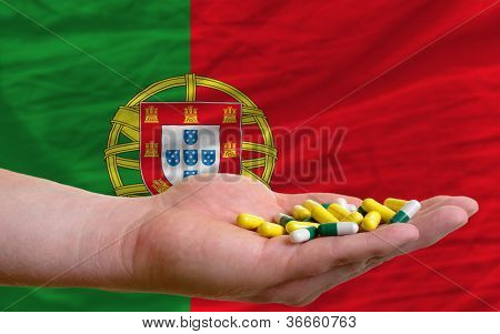 Holder piller i hånden foran Portugals nationale Flag