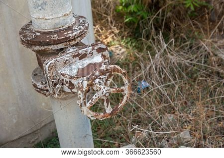 A Metal Pipeline Valve, Old Weathered Gas Crane And Pipe .old Valves Have Rust, Circular Handle, Old