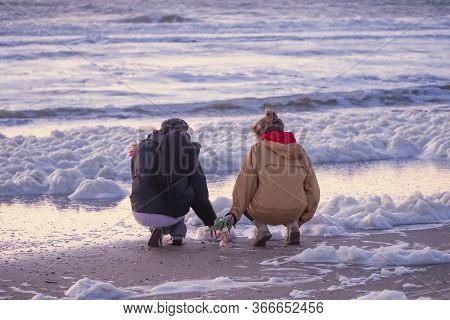 Scheveningen, May 14 2020: Scheveningen, The Netherlands. Two Women Emotionally Throw Flowers In The