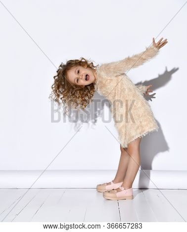 Curly Blonde Little Schoolgirl With Flowing Hair In Cute Pink Fuzzy Dress Leaning Head Forward Takin