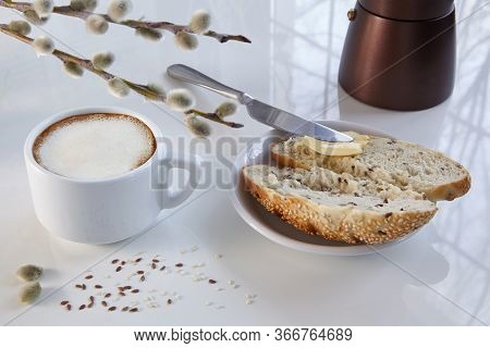 Cup Of Coffee, Geyser Coffee Maker And A Grain Bun With Butter On A White Table. Light From The Wind