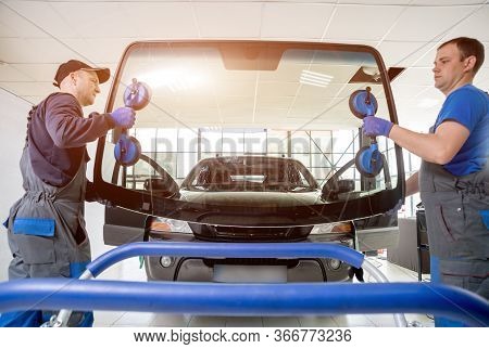 Automobile Special Workers Replacing Windscreen Of A Car In Auto Service