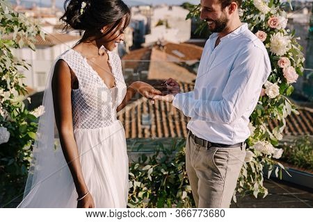 Mixed-race Wedding Couple - African-american Bride And Caucasian Groom. Groom Puts A Ring On Brides 