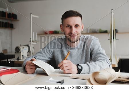 Smiling Man Doing Engineering Or Managing Work At A Generic Workshop. Local Small Business, Clothing