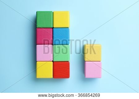 Flat Lay Composition With Colorful Cubes On Light Blue Background. Pareto Principle Concept