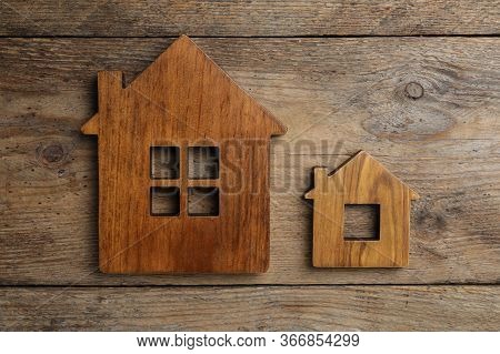 Small And Big House Figures On Wooden Background, Flat Lay. Pareto Principle Concept