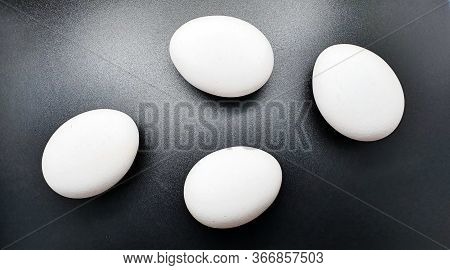 White Chicken Eggs Lie On A Black Background