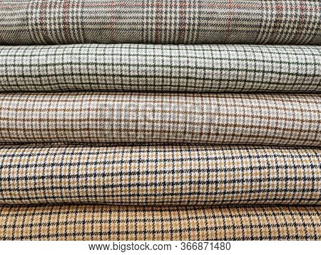 Rolls Of Different Checkered Fabrics For Sewing Coats Close-up. Samples Of Different Checkered Fabri