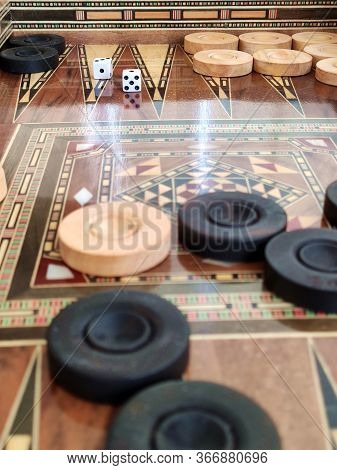 Backgammon With Wooden Inlay. Wooden Backgammon Board Game Of Pearl Inlaid On Brown Background.