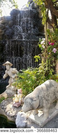 Beautiful Statue In Thailand Of A Pig And A Asian Fisherman In The Grand Palace In Bagkok