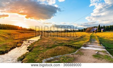Rural Grassland Landscape In Sunny Spring Evening. Sunset In Jizerka Village With Jizerka River, Jiz