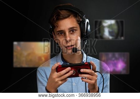 A Teenage Boy With Bruises Under His Eyes Playing A Computer Game. Transparent Screens With Games In