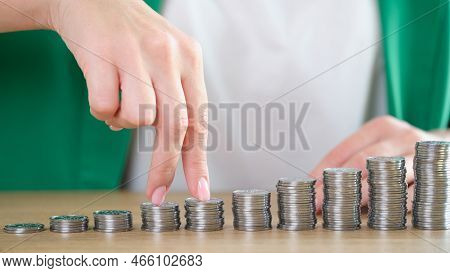 Close-up Of Woman Fingers Going Up On Bar Chart Collected Of Silver Coins. Business Growth, Increase