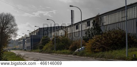 Ndustrial District. Industrial Plants Of Various Industries. A Street With Lanterns And Trees In Aut