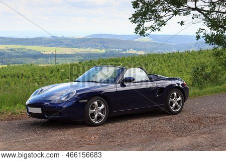 Gerolstein, Germany - June 28, 2021: Blue Roadster Porsche Boxster 986 With Eifel Mountain Panorama.