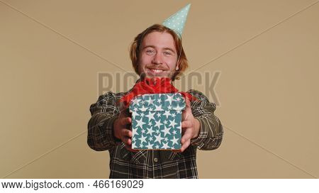Positive Smiling Bearded Man Presenting Birthday Gift Box Stretches Out Hands, Offer Wrapped Present