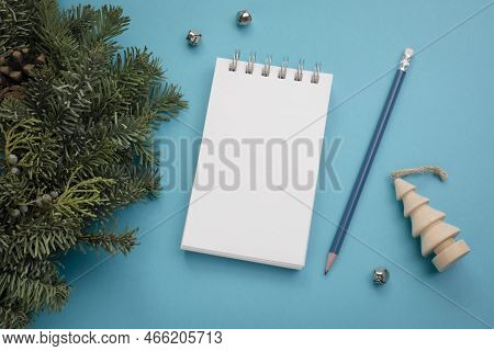View From Above On Blank White Notepad With Pencil On The Side, Christmas Wreath And Ornaments, On B