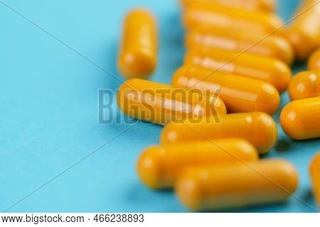 Turmeric Herb Yellow Medicative Capsules With Curcumin Powder On A Blue Background. Alternative Herb