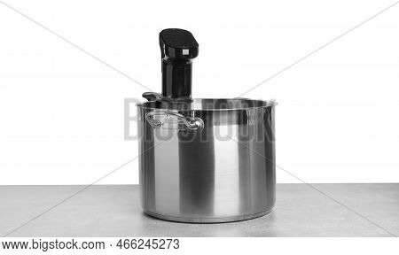 Sous Vide Cooker In Pot On Light Table Against White Background. Thermal Immersion Circulator