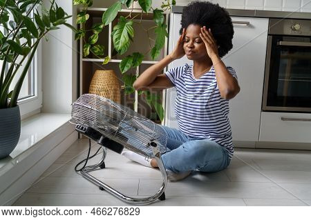 Unhappy African Female Suffering From Heat In Modern Apartment, Living Without Air Conditioning. Exh