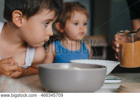 Two Little Caucasian Kids Learning To Cook Muffins At Kitchen. Kids Ready To Mix Ingredients, Cookin
