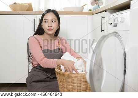 Exhausted  Asian Young Woman With Dirty Clothes , Doing Laundry In Home