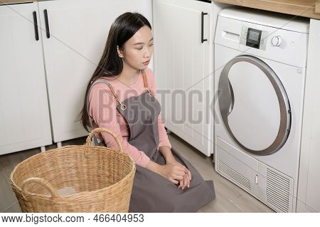 Exhausted  Asian Young Woman With Dirty Clothes , Doing Laundry In Home