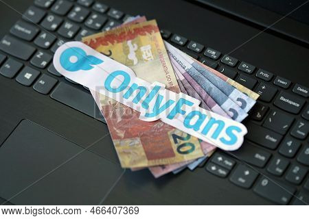 Ternopil, Ukraine - September 6, 2022 Onlyfans Paper Logotype On Bunch Of Brazilian Reals Bills Lies